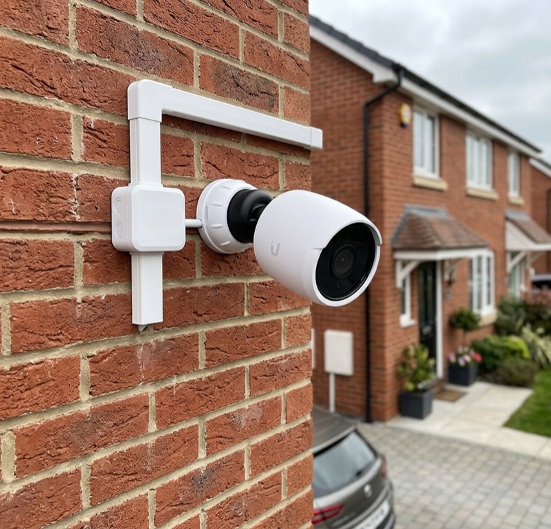 Professional CCTV camera installed on a British semi-detached house with neat cable trunking.